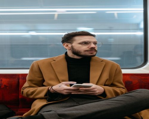 Person holding a smartphone while sitting on public transport