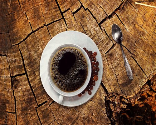 A glass of water next to a morning cup of coffee